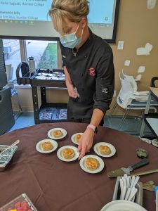 Chef Kasey Wesley, getting ready to serve Sweet potato & cheese fluffy tofu cup cake to judges